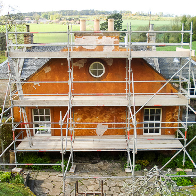 Stone repair and lime harling on an old stone cottage.